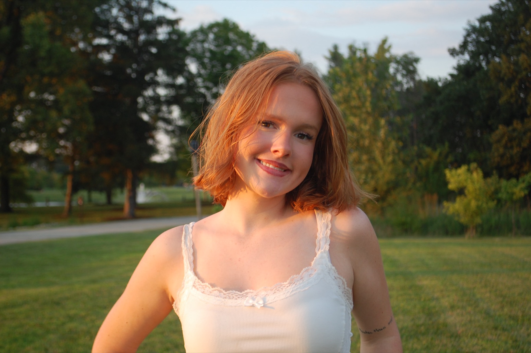 Teagan smiling outdoors in warm evening light